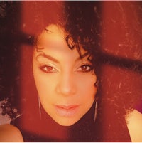 a woman with curly hair is posing for a photo